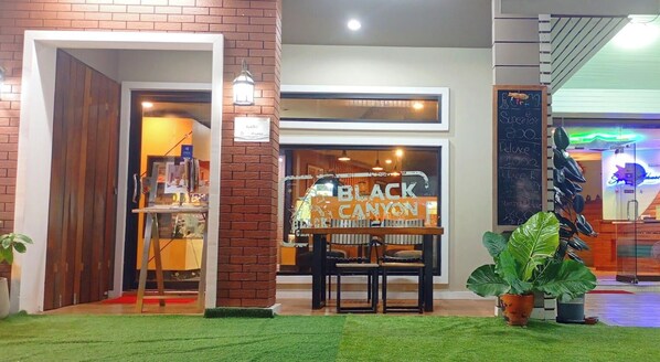 A storefront with a sign reading 'BLACK CANYON' and a chalkboard menu. - Sea Star House (Krabi)