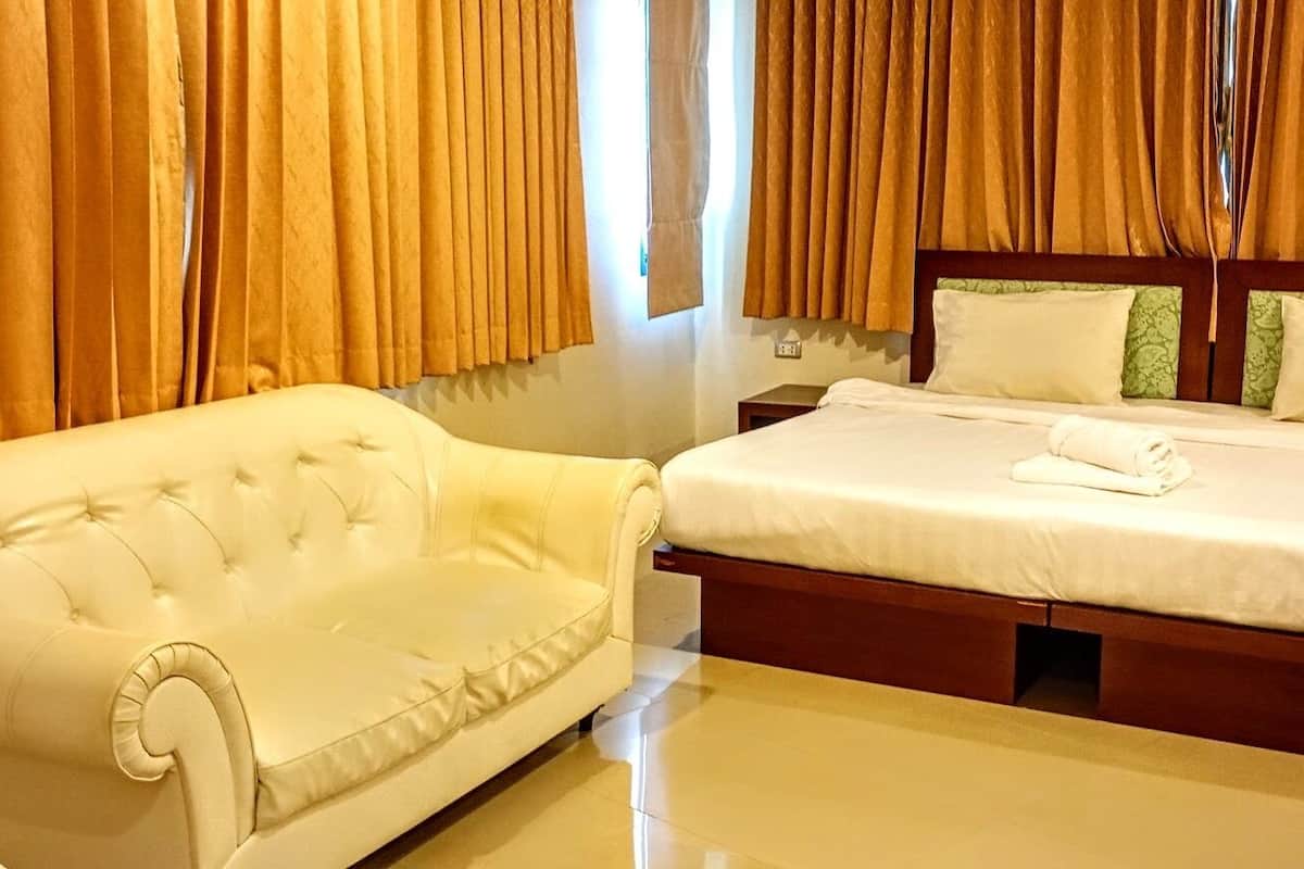 Ein Hotelzimmer mit einem Bett, einem weißen Sofa und Vorhängen.