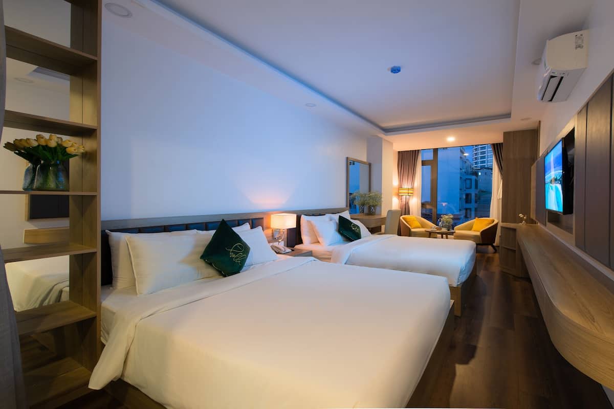 Une chambre d’hôtel avec deux lits, une télévision, un bureau et une chaise.