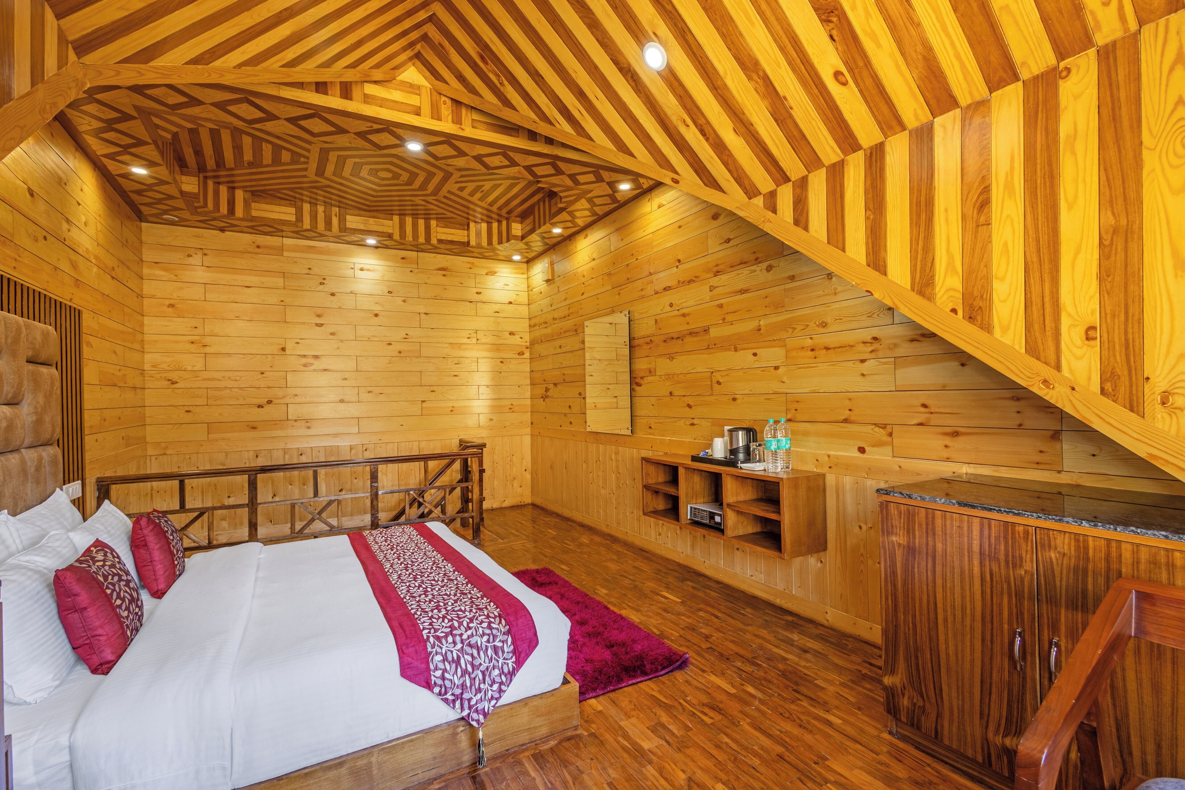 Una cabaña de madera con una cama, un banco y una pequeña kitchenette.