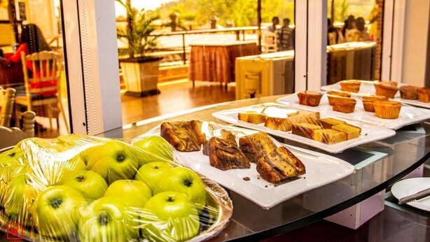 A buffet with green apples, bread, and muffins. - Conference Hotel (Abeokuta)