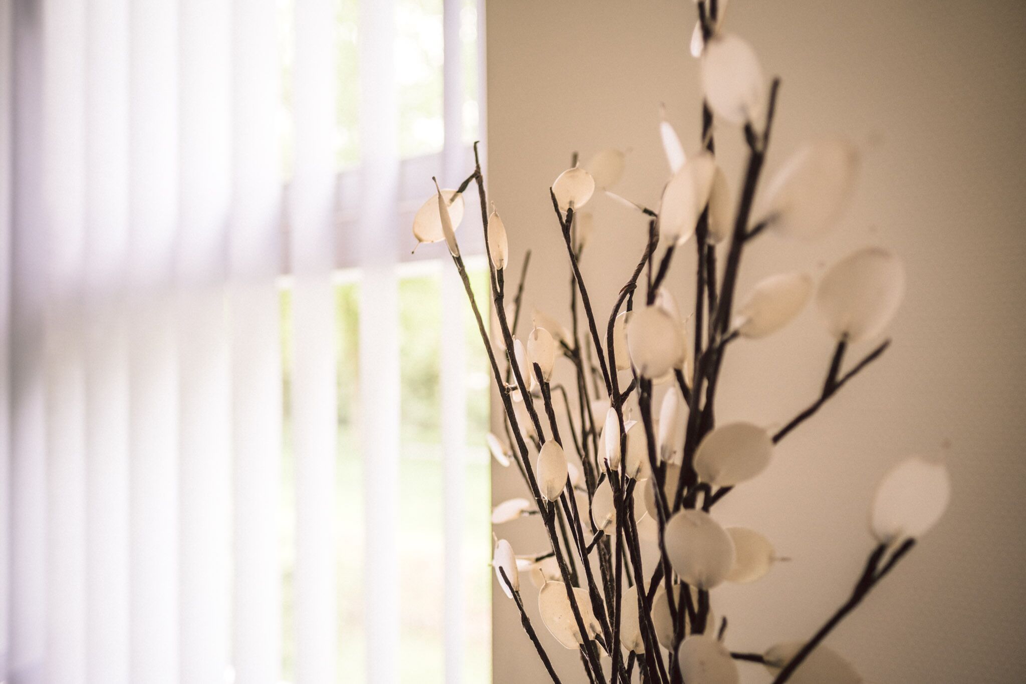 Um ramo em close-up com flores brancas, provavelmente parte de uma composição decorativa para interiores.