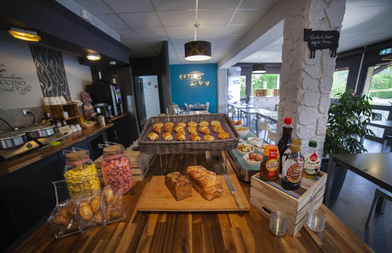A breakfast buffet with pastries, bread, and condiments.