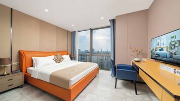 A hotel room with a bed, a desk, a chair, a television, and a view of the cityscape.