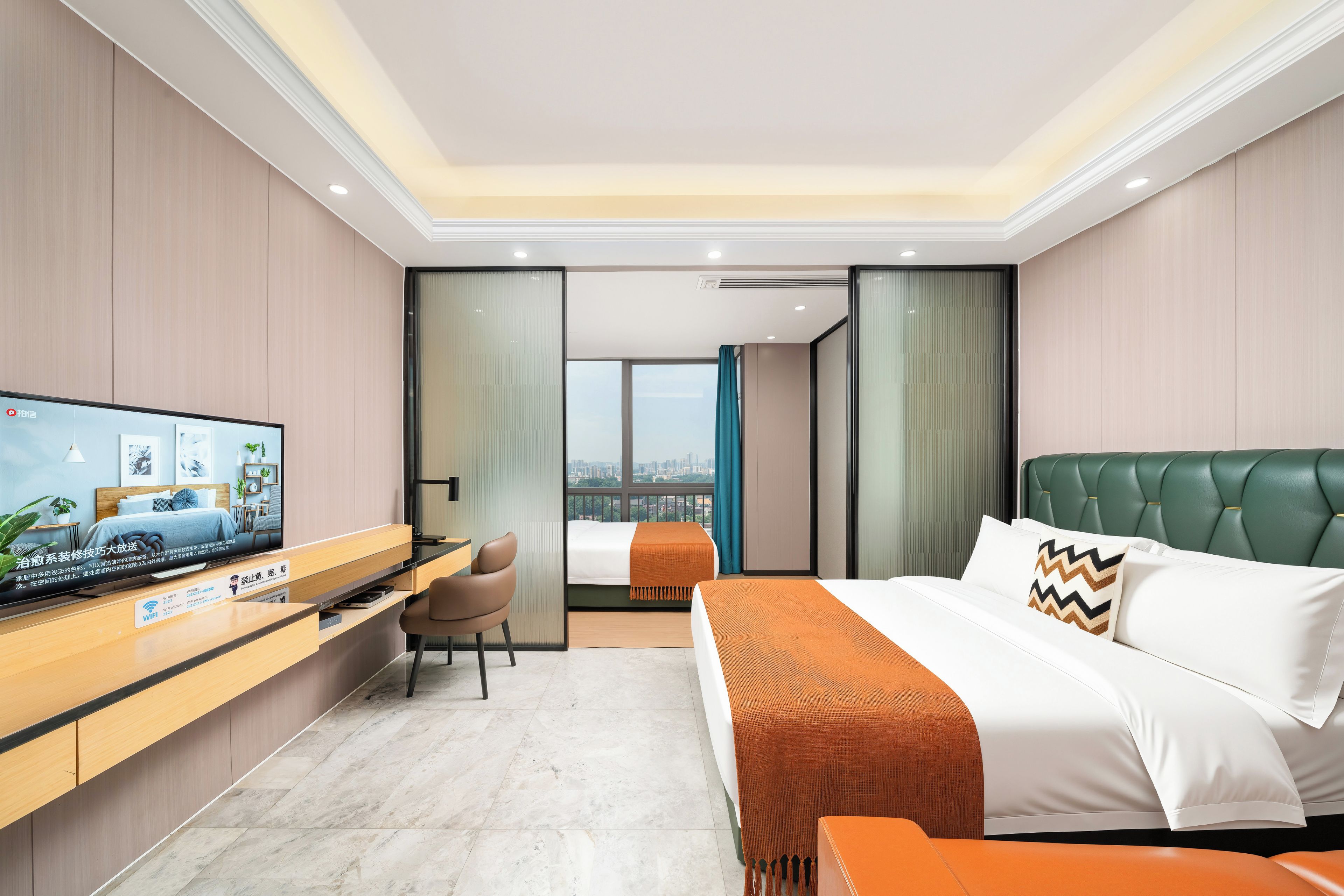 Une chambre d’hôtel moderne équipée d’un lit, d’un bureau, d’une télévision et offrant une vue sur la ville.