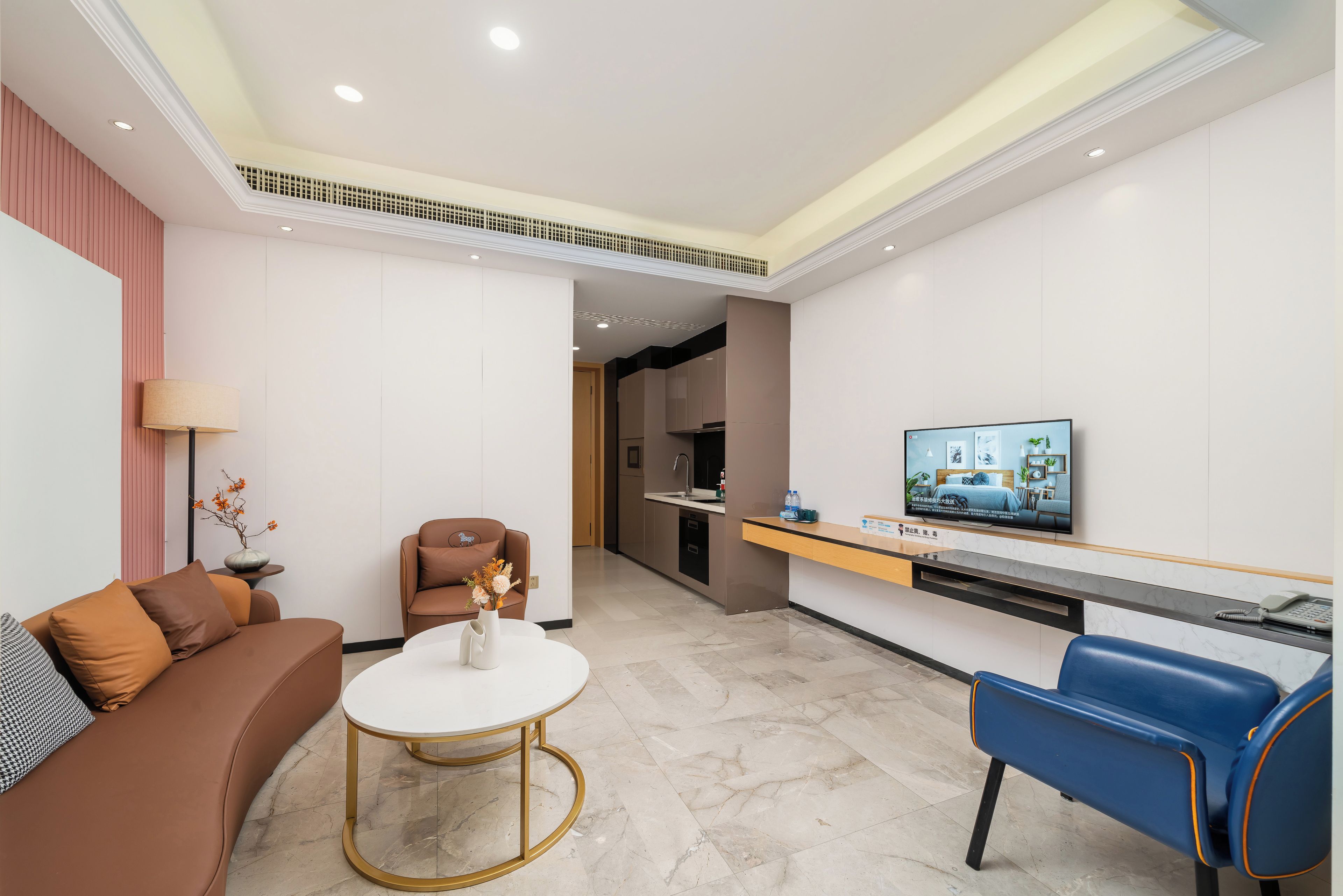 Una sala moderna con un sofá, una mesa de centro, un televisor y una zona de estar.