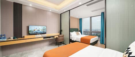 Quarto de hotel com cama, escrivaninha, televisão e vista para a cidade.