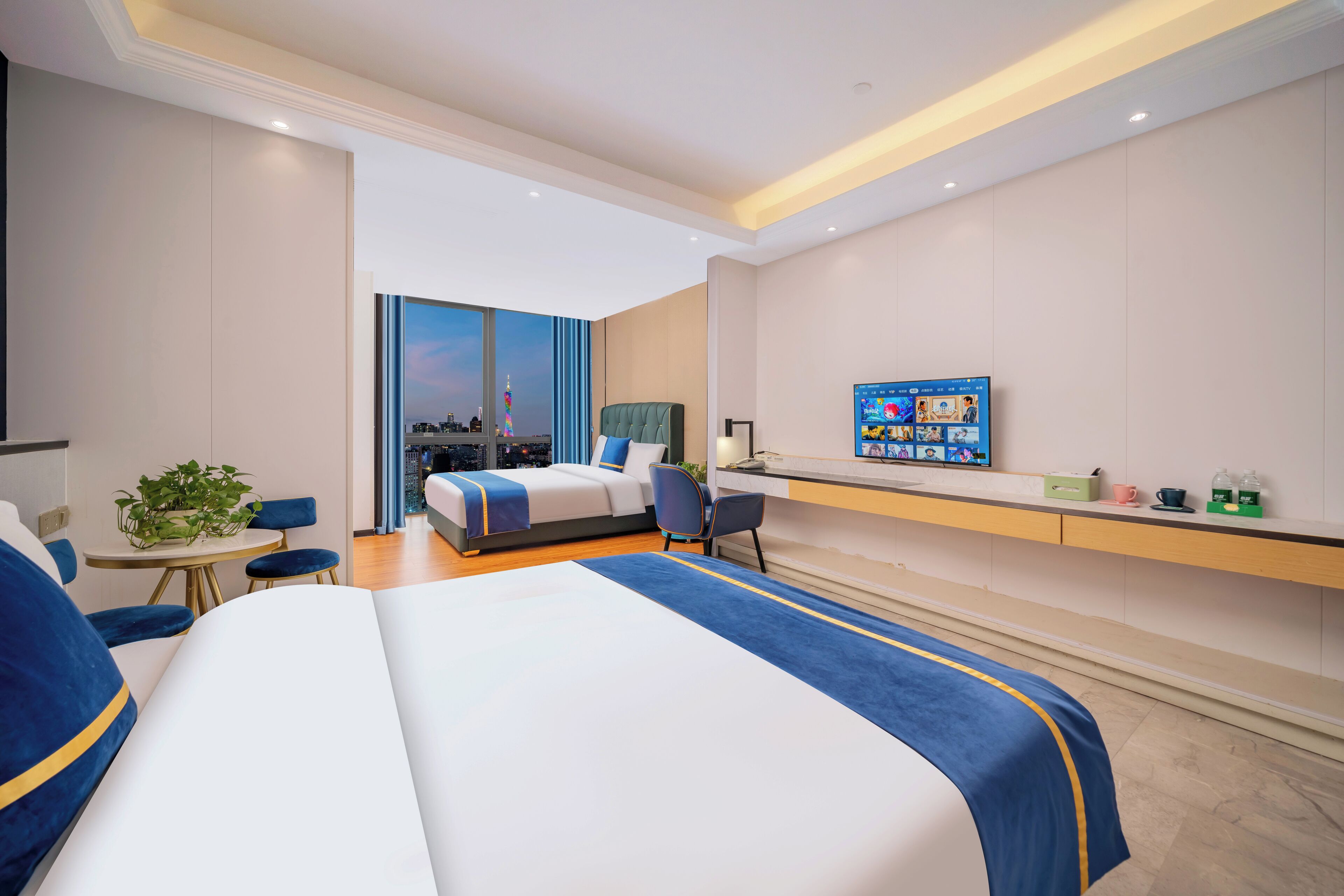 A modern hotel room with a large bed, a desk, and a city view.