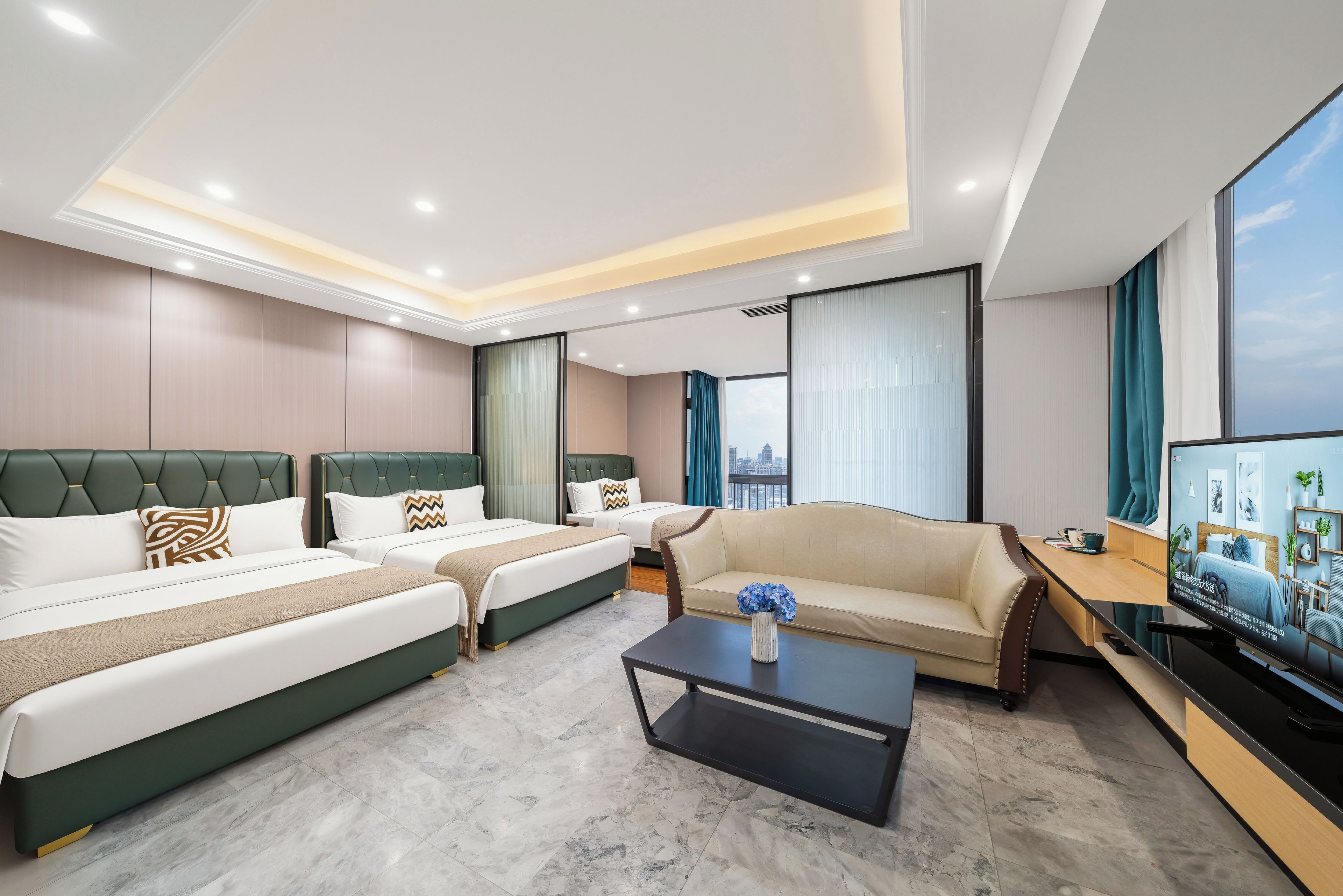 A hotel room with two beds, a sofa, a coffee table, and a TV.