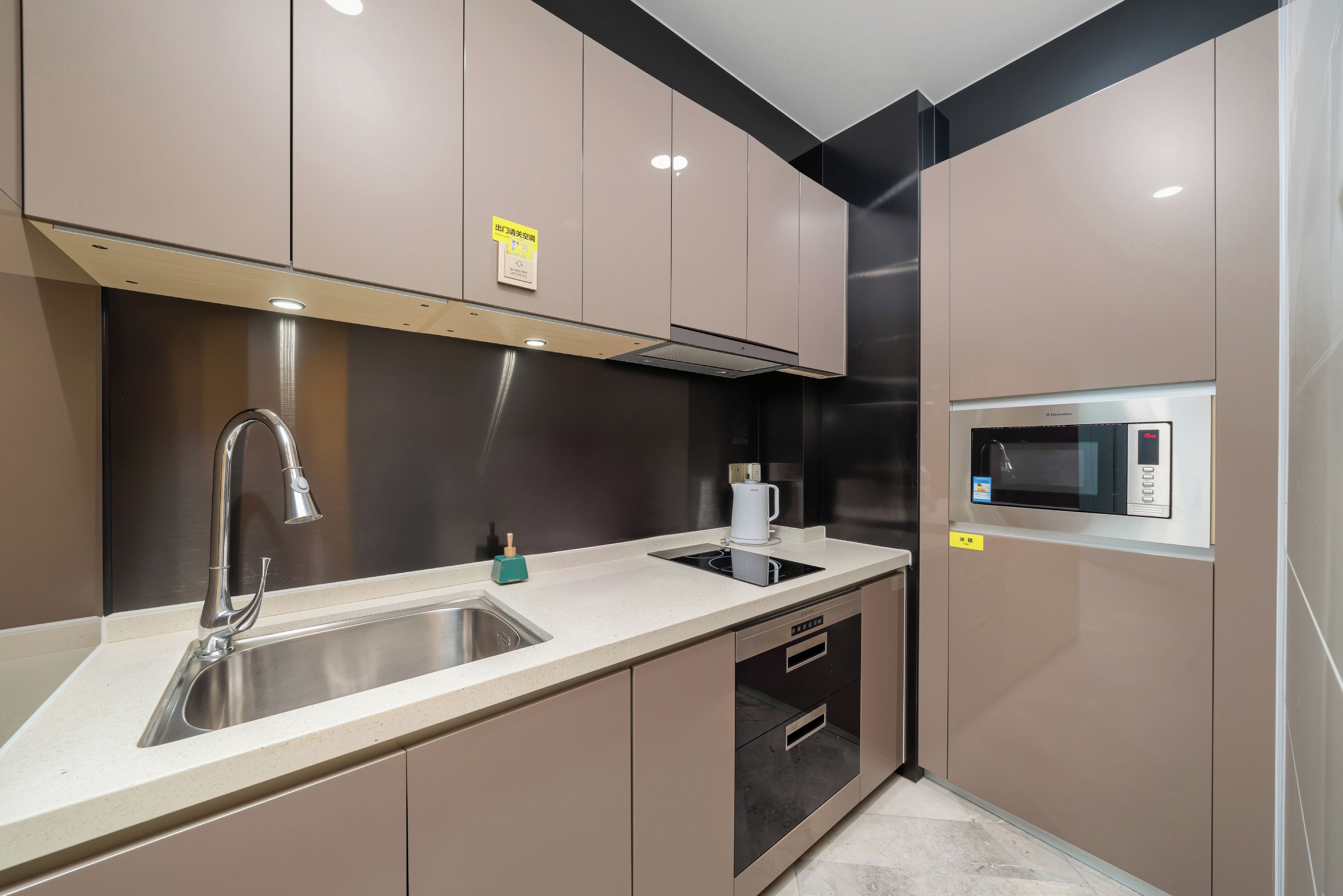 A modern kitchen with a stainless steel sink, a built-in microwave, and a gas stove.