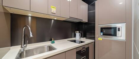 A modern kitchen with a stainless steel sink, a built-in microwave, and a gas stove.