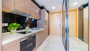 A modern kitchen with stainless steel appliances, a marble countertop, and a potted plant. - Cloudy International Apartment (Guangzhou)