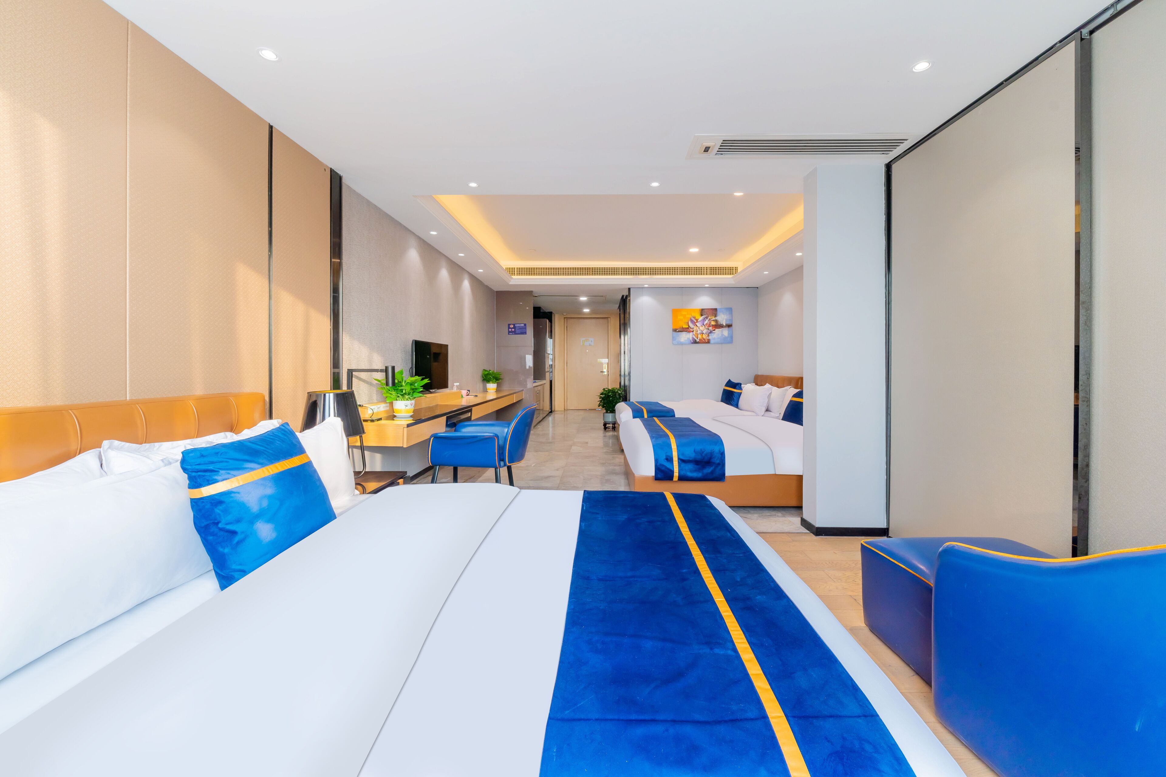Une chambre d’hôtel moderne dotée d’un grand lit, d’un bureau et d’un coin salon.