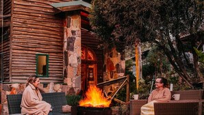Two people sitting on wicker furniture outdoors with a fire pit between them. - CIRQUE 5 -  Two bedroom alpine lodge (Merrijig)