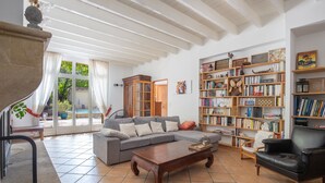 A spacious living room with a grey sectional sofa, a wooden coffee table, and a bookshelf filled with books.