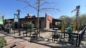 Un edificio de ladrillo con mesas al aire libre y un letrero que dice 'La Unica Bar & Grill'.