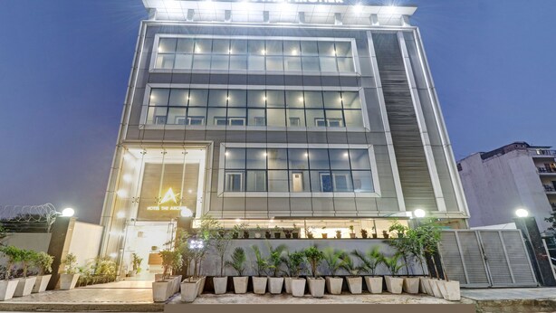 A modern hotel with a prominent sign reading "HOTEL THE ARCHER". - Hotel the Archer (Gurugram)