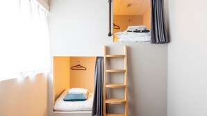 A compact room with a bunk bed, a wooden ladder, a small shelf, and a hanging coat rack. - Akasaka The Hostel (Tokyo)
