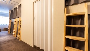 A hallway with a closet, wooden shelves, and a window with curtains. - Akasaka The Hostel (Tokyo)