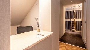 A modern, compact room with a desk, chair, and a bunk bed with a ladder. - Akasaka The Hostel (Tokyo)