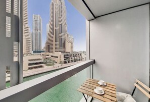 Enjoy a panoramic view of the city from this balcony, featuring a table for relaxation or casual gatherings.