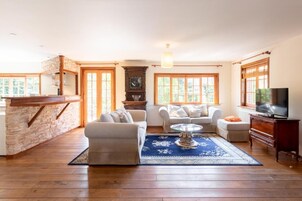 Casa família, 2 quartos | Área de estar | Smart TV 45 cm com canais digitais, livros