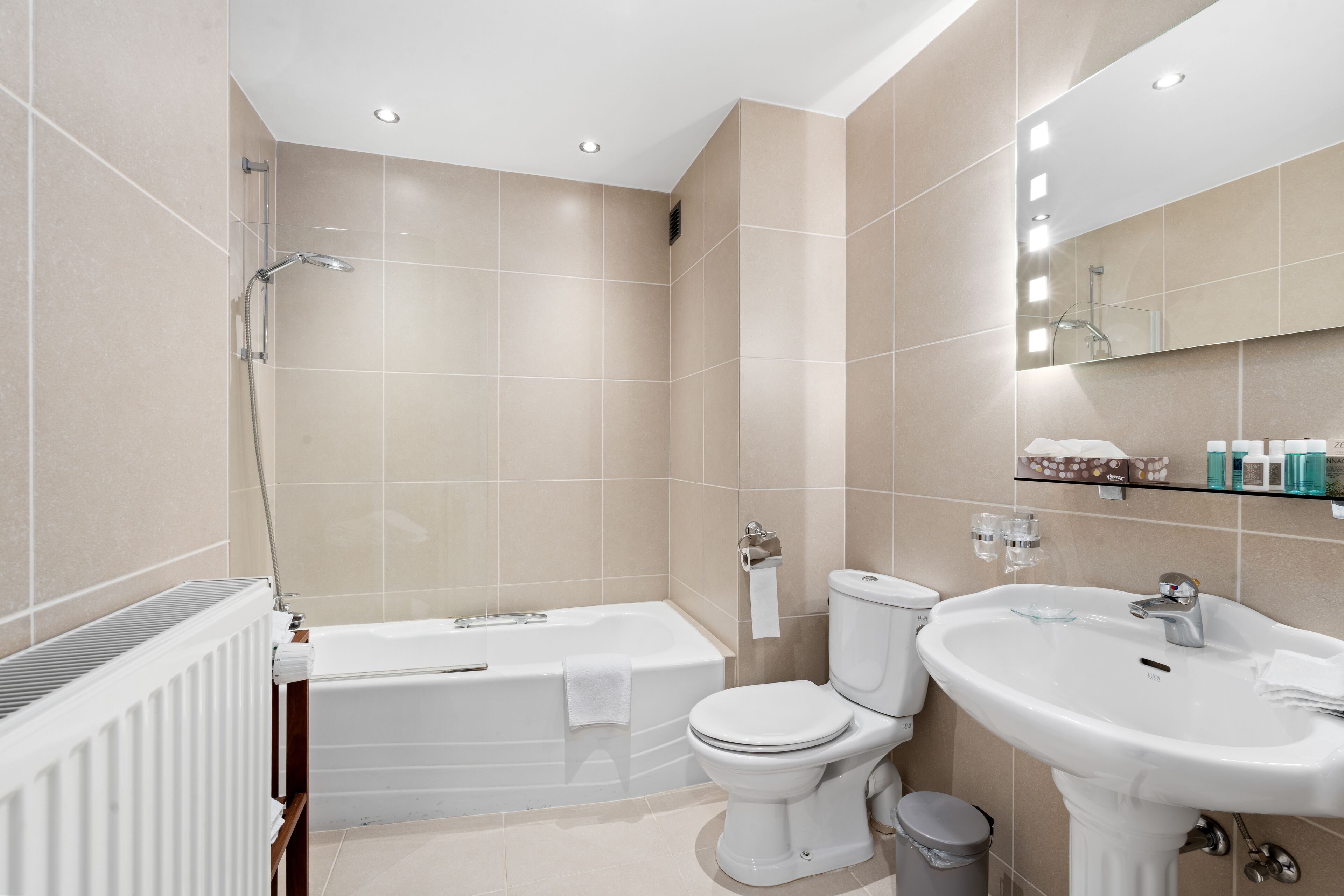 A modern bathroom with a bathtub, toilet, and sink.