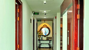 A hallway with a mirror, a ceiling fan, and a sign indicating a restroom. - HANZ Cao Gia Hai Hotel (Ho Chi Minh City)