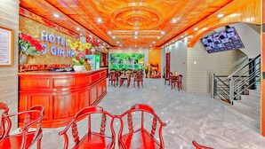 A hotel lobby with a reception desk, seating area, and a staircase. - HANZ Cao Gia Hai Hotel (Ho Chi Minh City)