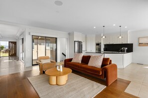 A modern living room with a sofa, coffee table, and a view to the outside.