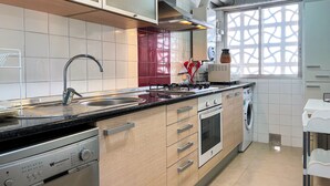 A modern kitchen with a stainless steel sink, a built-in oven, and a dishwasher. - Apartment 4/5 Pax with direct access to the beach. It has a community pool. Excellent location, bars, restaurants, shops and promenade. Free WIFI. Vivalidays Mar. (Santa Susana)