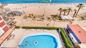 A hotel with a swimming pool, beach view, and a restaurant. - Apartment 4/5 Pax with direct access to the beach. It has a community pool. Excellent location, bars, restaurants, shops and promenade. Free WIFI. Vivalidays Mar. (Santa Susana)