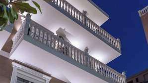 A multi-story building with balconies, a white railing, and a window with shutters. - Elite Hotel (Sarandë)