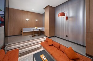 A modern living room with a sofa, a coffee table, and a dining area with a bench and table.