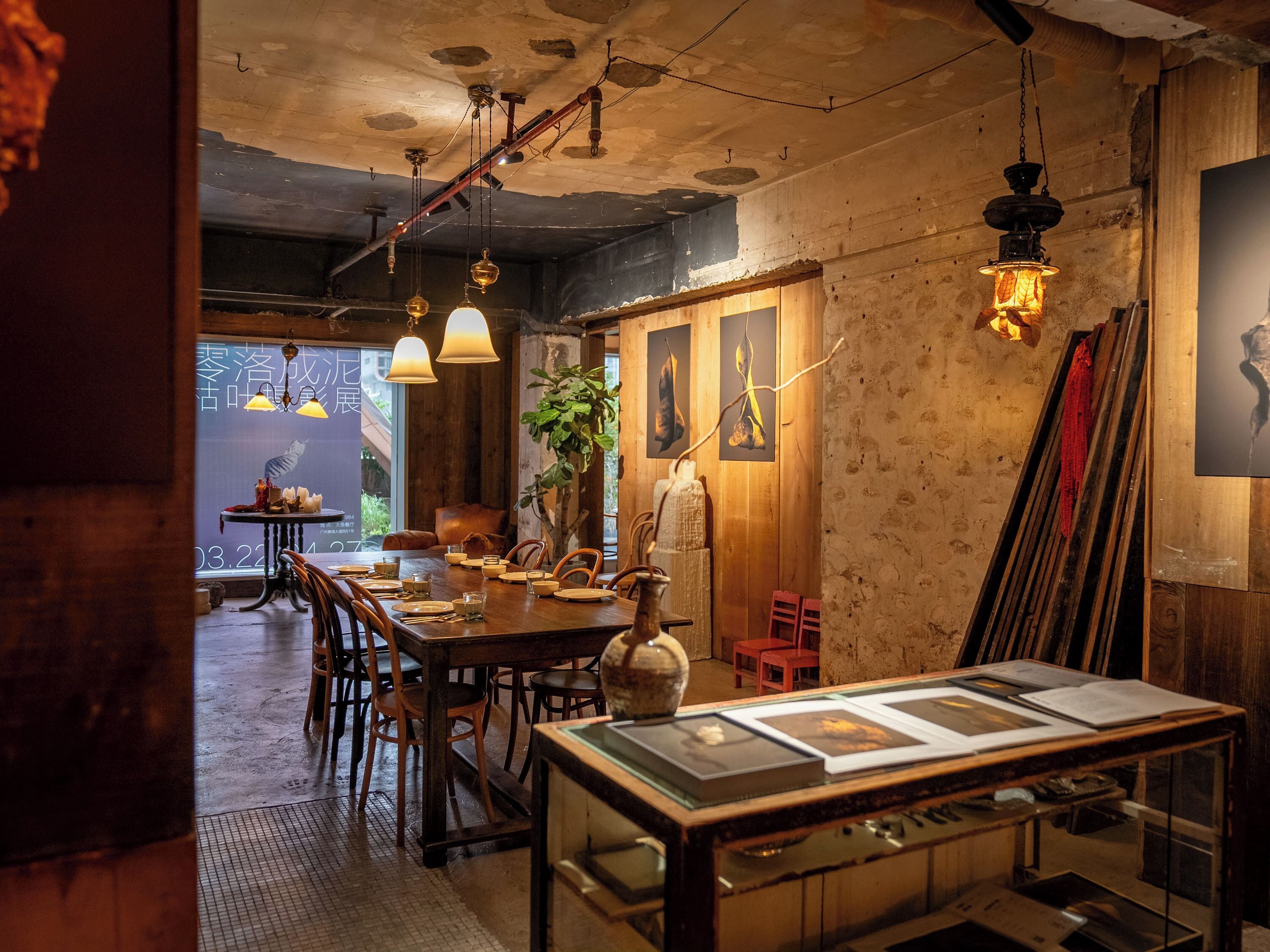 A restaurant with wooden walls, hanging pendant lights, and a dining area with tables and chairs.