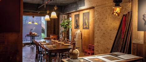 A restaurant with wooden walls, hanging pendant lights, and a dining area with tables and chairs.