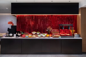 Un banco buffet con diversi cibi e una postazione per il caffè.