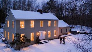 A two-story house with a snow-covered roof and a front porch. - Green Sanctuary: Luxury Home Surrounded by Nature (New Paltz)