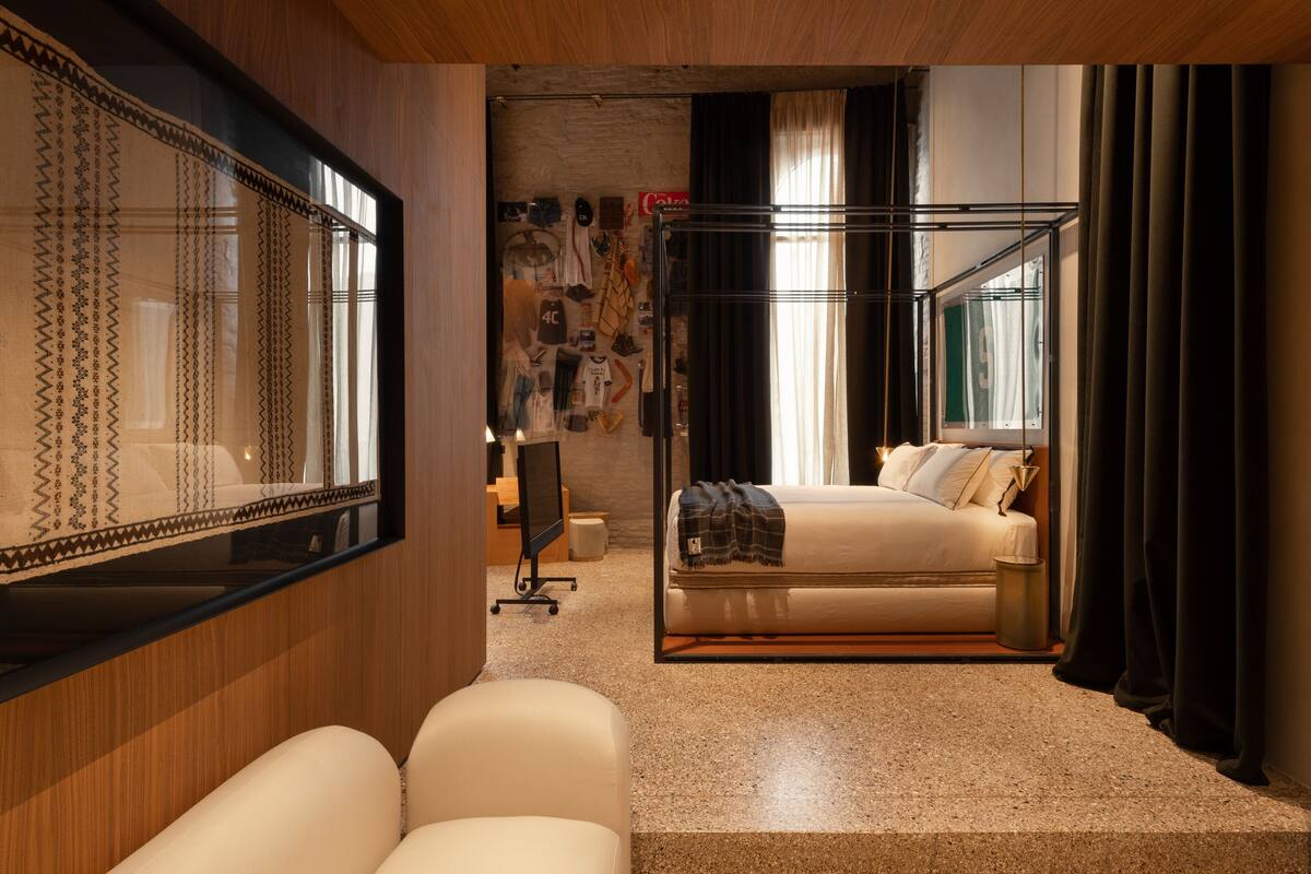 Een moderne hotelkamer met een groot bed, een zithoek met een stoel, een bureau en een grote spiegel.
