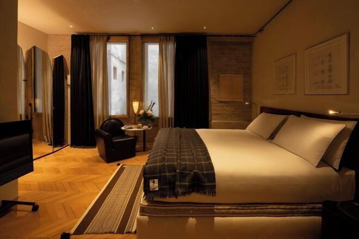 Een hotelkamer met een bed, een televisie, een bureau en een stoel.