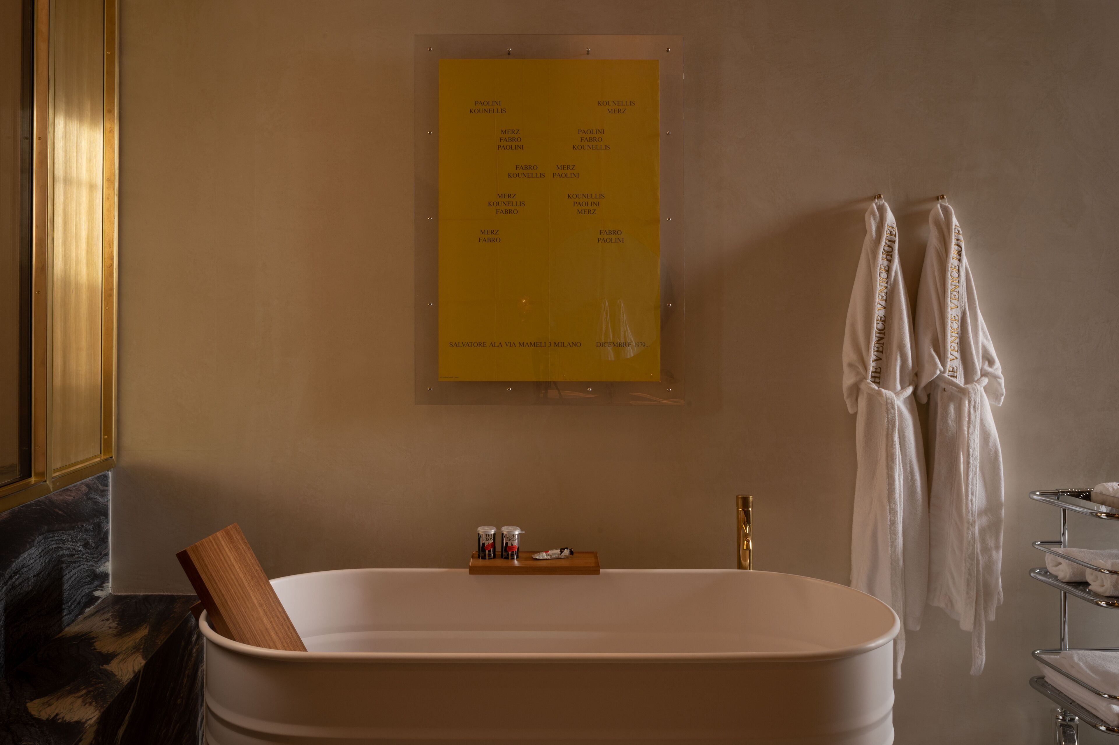 Ein Badezimmer mit einer Badewanne, einem Holztablett und einem Handtuchhalter mit Handtüchern.