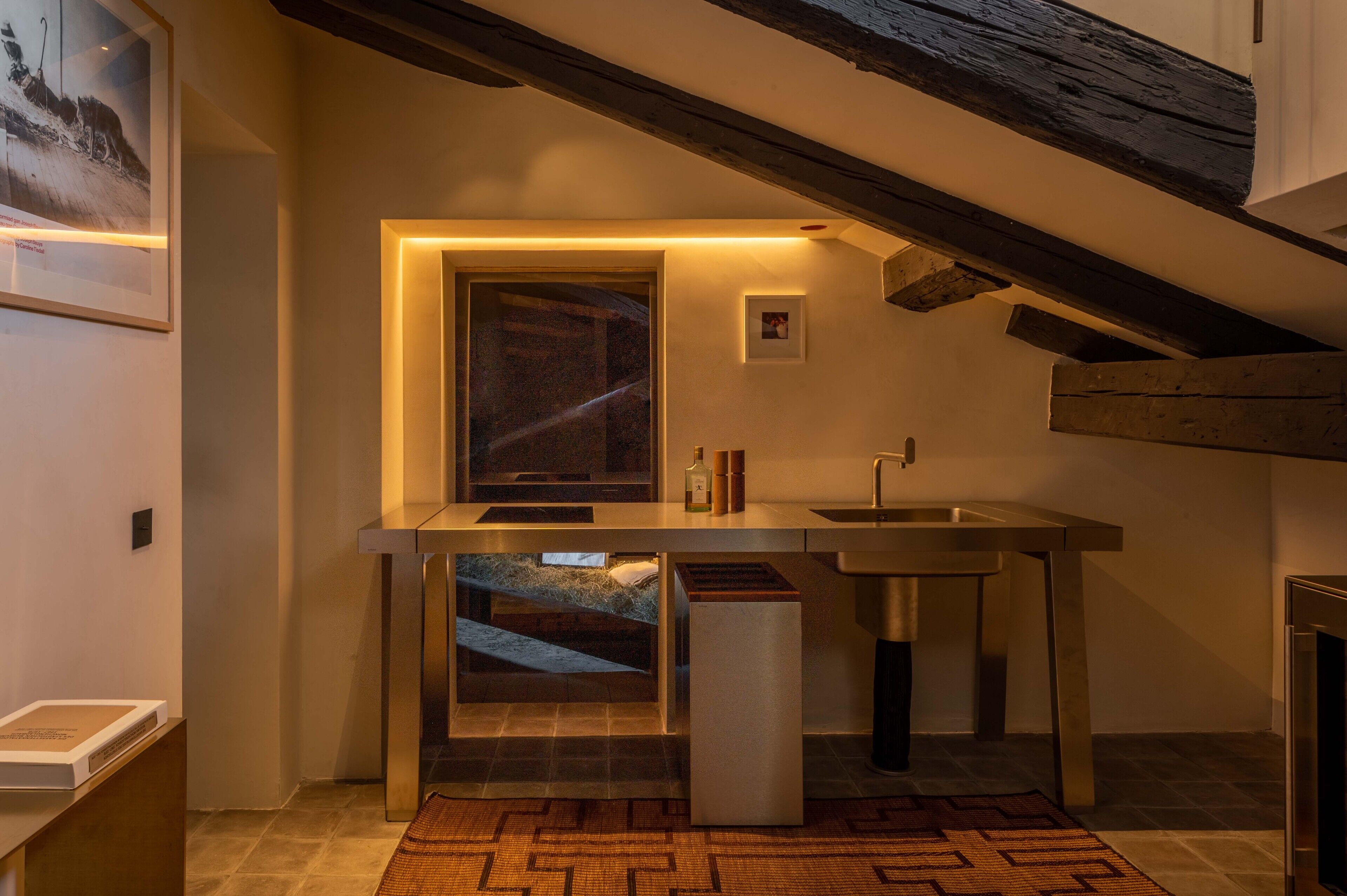 Eine moderne Küche mit eingebautem Backofen, einer Spüle und einem Fenster über der Arbeitsfläche.