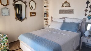 A neatly arranged bedroom with a bed, bedside table, and a chair. - Apartment with the most beautiful sunset in Sicily (Frazione Cava d'Aliga, Scicli)