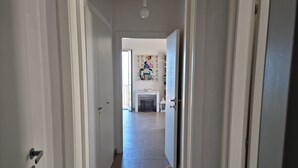 A hallway leading to a room with a fireplace and a colorful painting on the wall. - Apartment with the most beautiful sunset in Sicily (Frazione Cava d'Aliga, Scicli)
