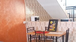 Ein modernes Wohnzimmer mit Sofa, Couchtisch und Essbereich.