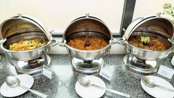 Tres dispensadores de acero inoxidable para alimentos con etiquetas sobre una encimera.