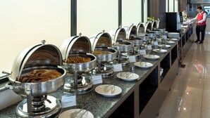 A buffet line with various food options, including French toast and paratha, in a modern hotel setting.