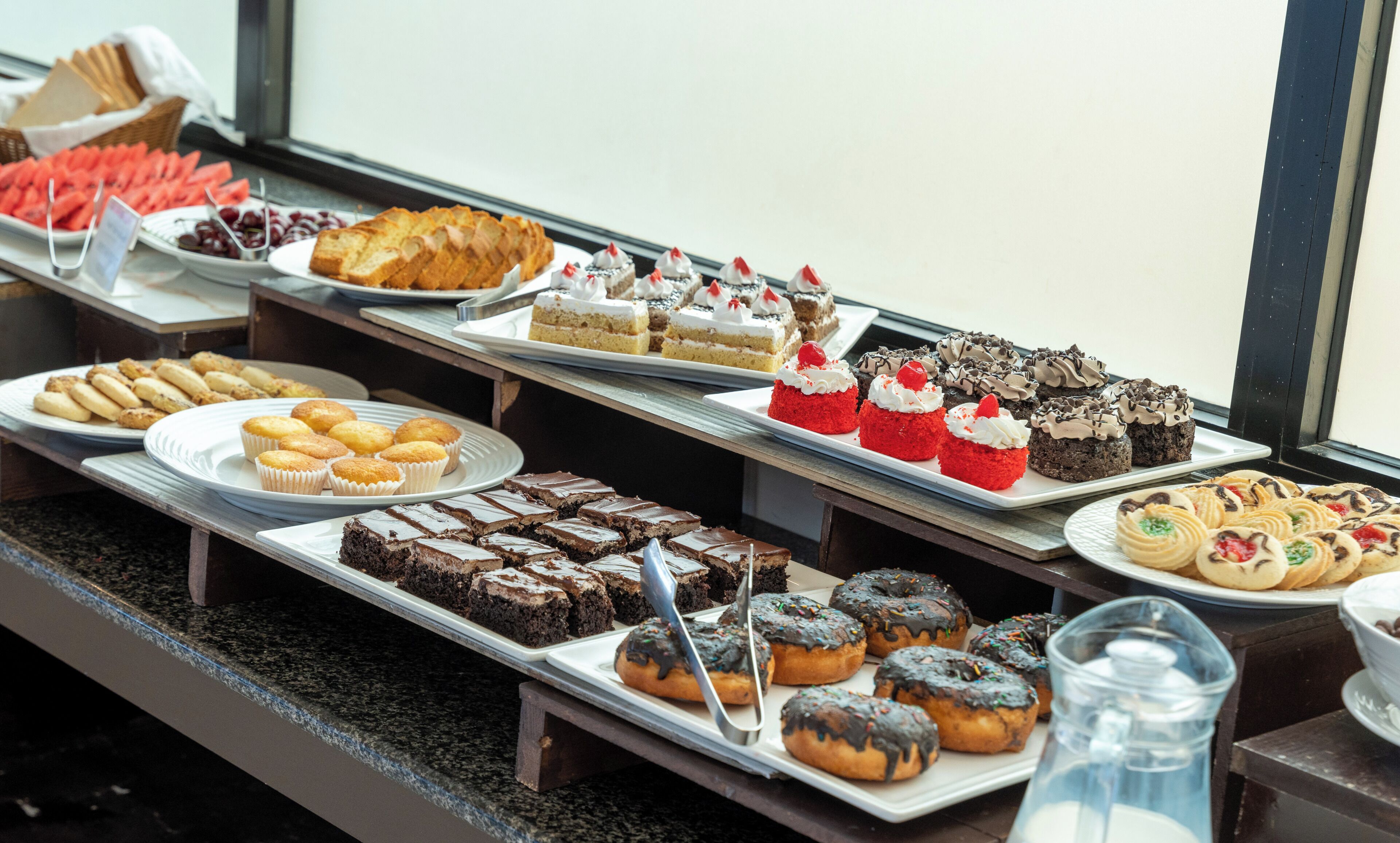 A buffet table with various desserts and pastries.
