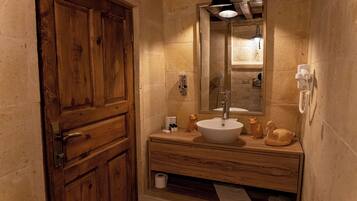 A wooden cabinet with a mirror, a sink, and decorative items on a wooden vanity.