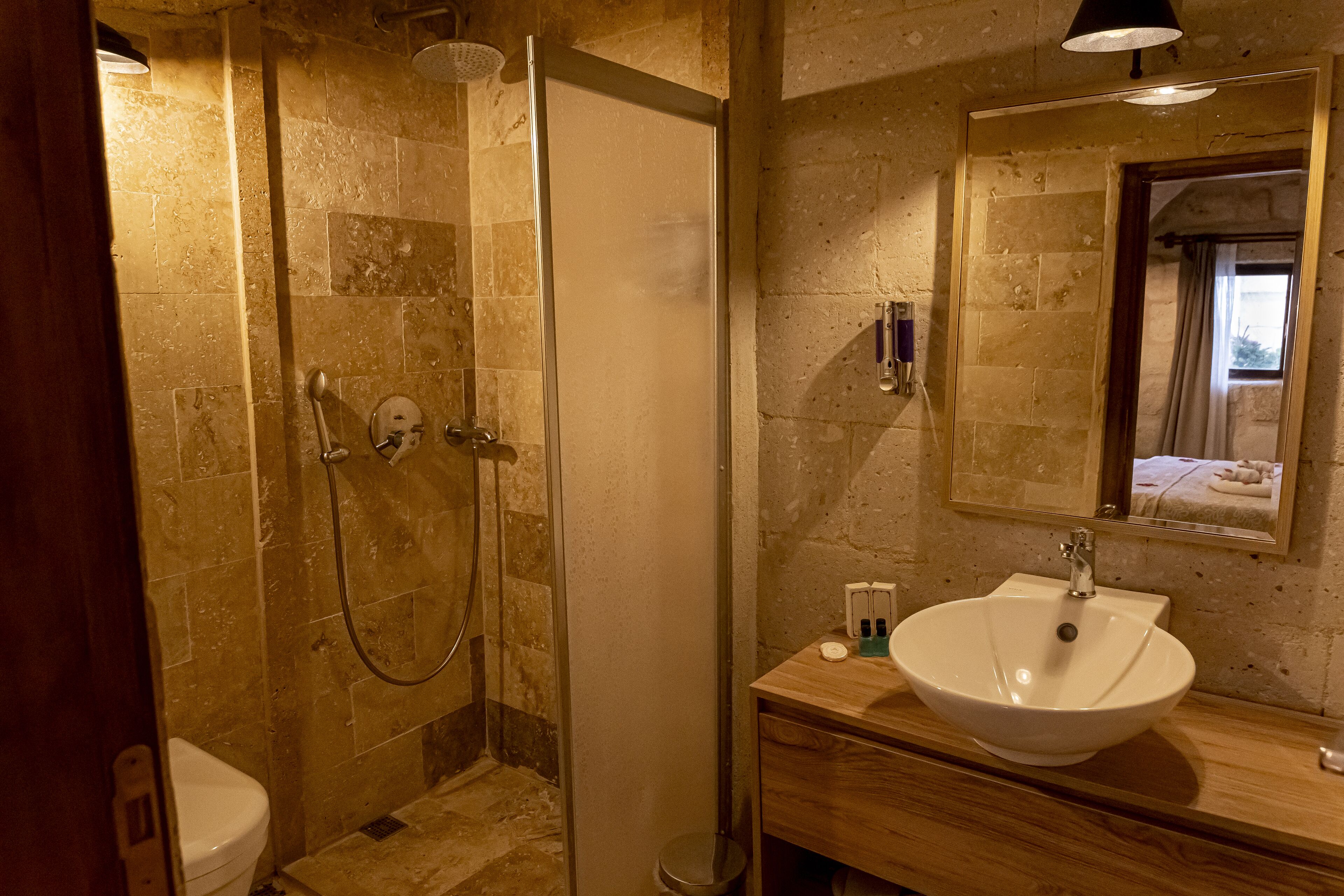 A bathroom with a glass-enclosed shower, a white sink, and a mirror above the sink.